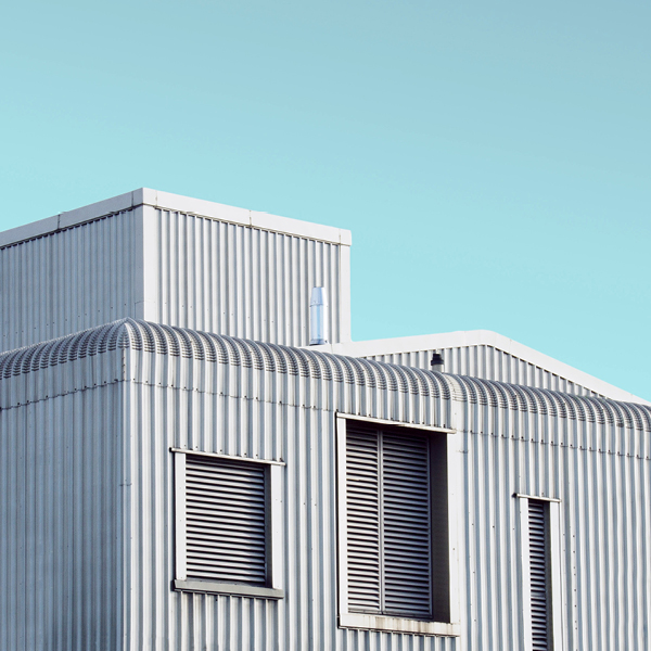 Zoomed-in image of the outside of a building with a light blue sky above it.